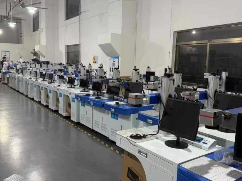 Industrial robotic arm performing automated laser welding in a manufacturing cell